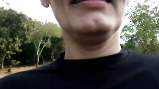 A hot older woman giving a blowjob to a pedestrian in the middle of the street during the day.